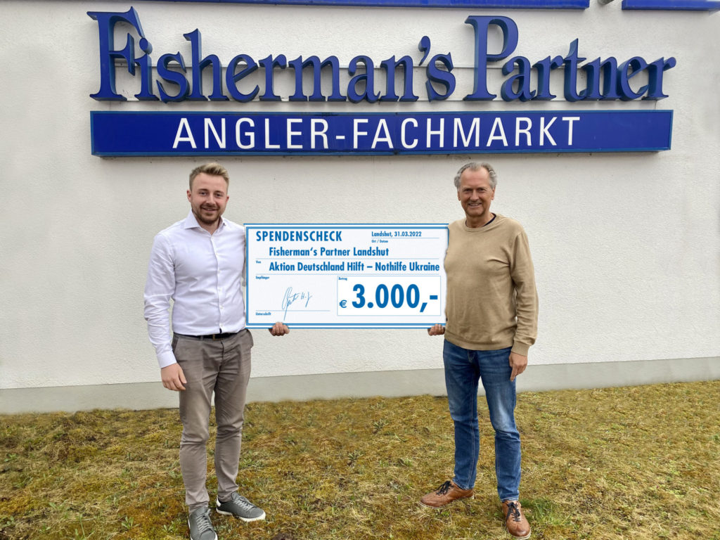 Stolz präsentieren Maximilian Kaiser und Hans-Jürgen Gäbler von Fisherman’s Partner den Scheck über 3.000 Euro der an die Aktion „Deutschland hilft – Nothilfe Ukraine“ übergeben werden konnte. Foto: Fisherman's Partner
