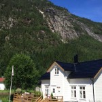Vor einer riesigen Felsformation liegt das beschauliche Ferienhaus in Stranda am Vadheimsfjord. Foto: Borks