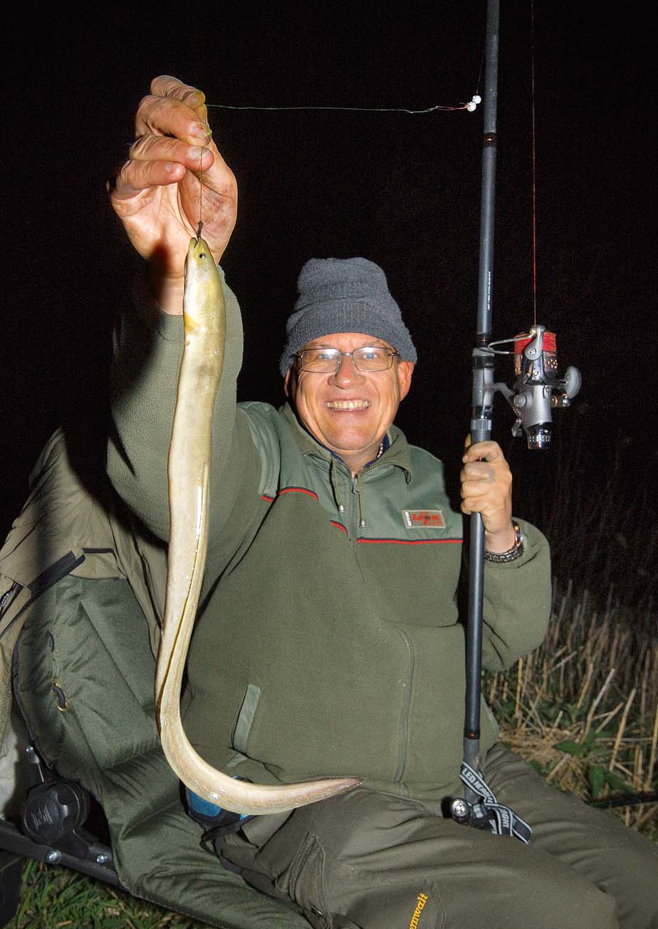 Angler mit Aal in der Nacht