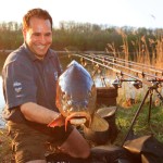 Karpfenangler mit Fisch hat die Fehler beim Karpfenangeln vermieden
