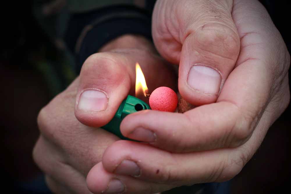 Mit einem Feuerzeug wird der Knoten angeflemmt, der Köder darf dabei nicht in Mitleidenschaft gezogen werden. 