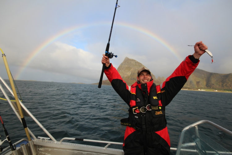 Angler mit Regenbogen im Hintergrund