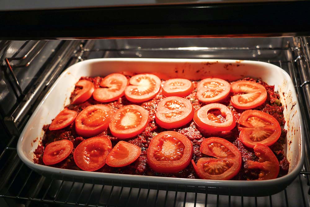 Tomatenscheiben auf dem Auflauf verteilen und bei ungefähr 180 Grad für ca. 25 Minuten in den Backofen schieben. 