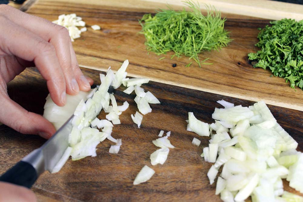 Zwiebeln und Knoblauch sehr klein würfeln. Dill und Petersilie klein schneiden. Diese Vorbereitungsarbeiten sorgen dafür, dass später ohne Zeitverlust gekocht werden kann.