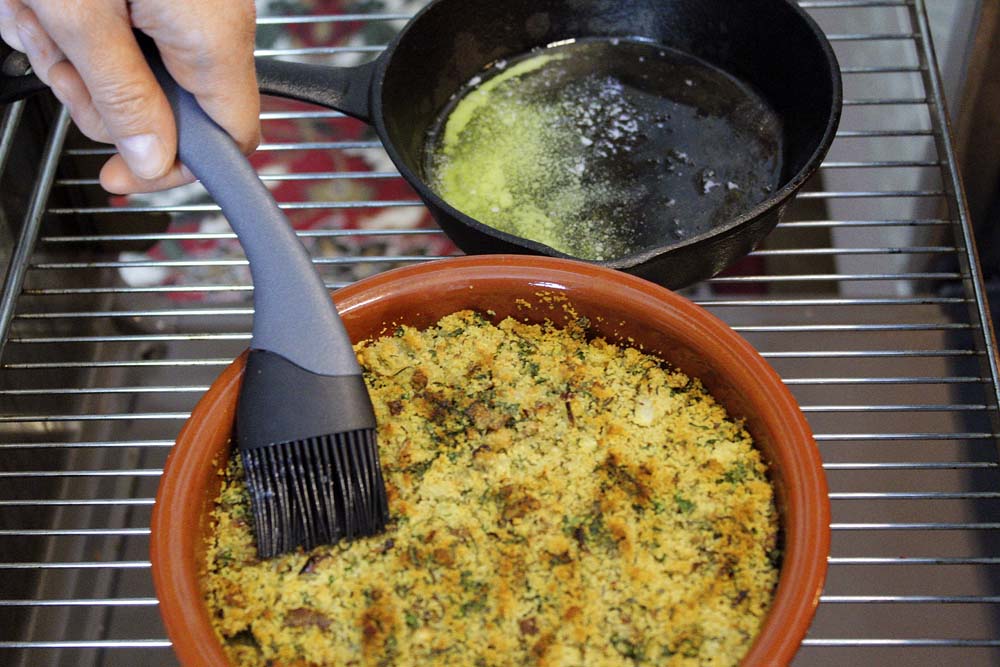 Nach der Hälfte der Garzeit am Rand der Auflaufform etwas Fischfond nachgießen und ein bisschen geschmolzene Butter über die Kruste pinseln.