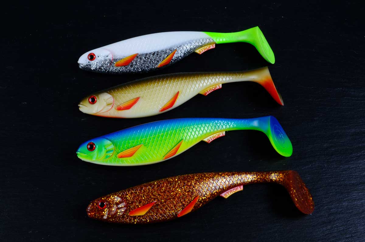 Hier sieht man die vier Farben des Gummifisches: Der Silver-Fire Fin (oben), Olive-Fire Fin, UV Blue-Fire Fin und der Motoroil-Fire Fin (unten).