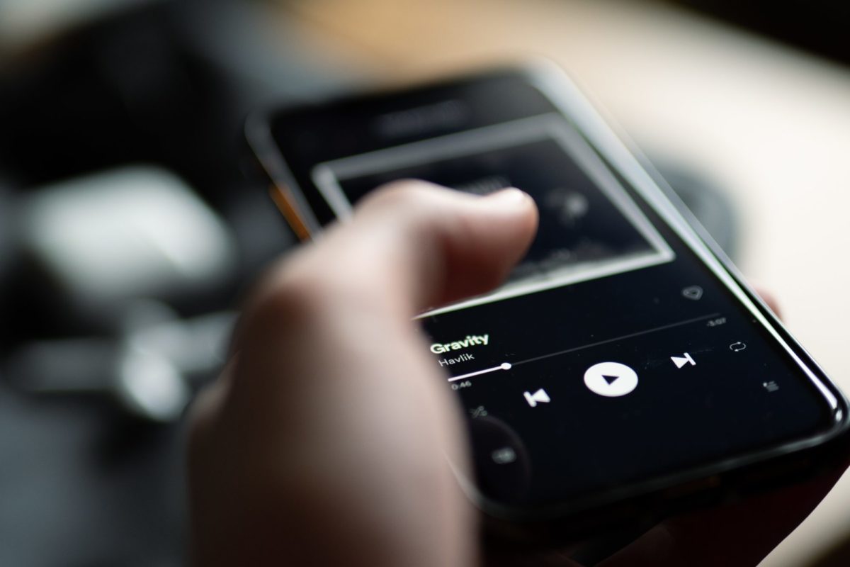 Spotify-Playlist. Ein Mann tippt auf seinem Handy.