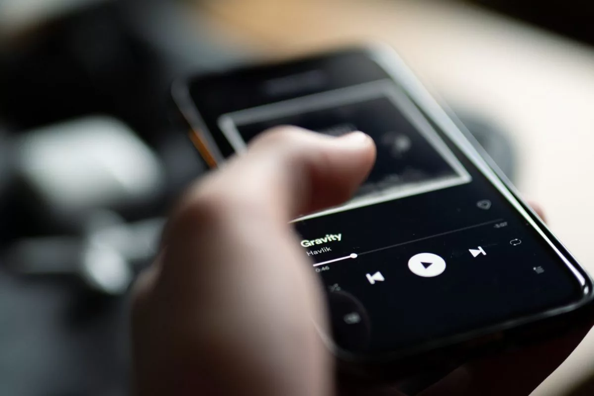 Spotify-Playlist. Ein Mann tippt auf seinem Handy.