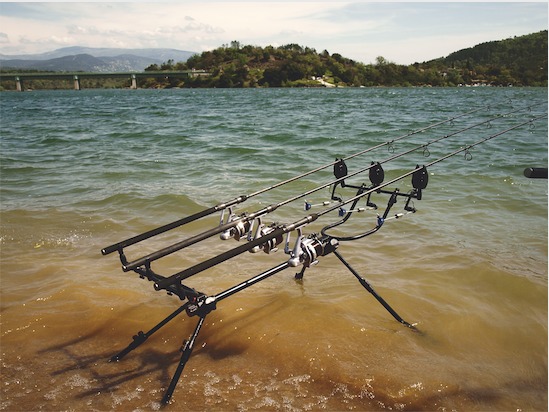 Am Ufer ist ein Rod Pod montiert, an dem vier Stangen aus dem Wasser ragen.