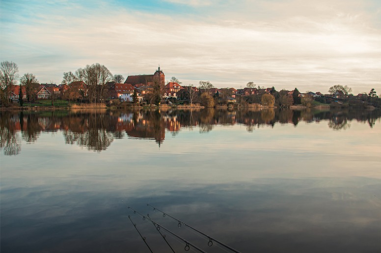 Panorama-Aufnahme eines Parksee mit Stadtbild im Hintergrund