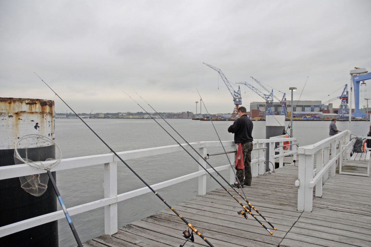 Meeresangeln im Winter: Angler auf einer Seebrücke in der Kieler Förde