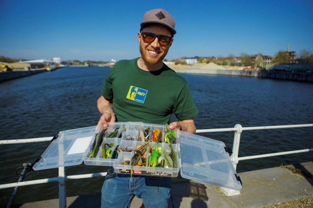 Angler mit Köderbox voller Zander-Gummifische