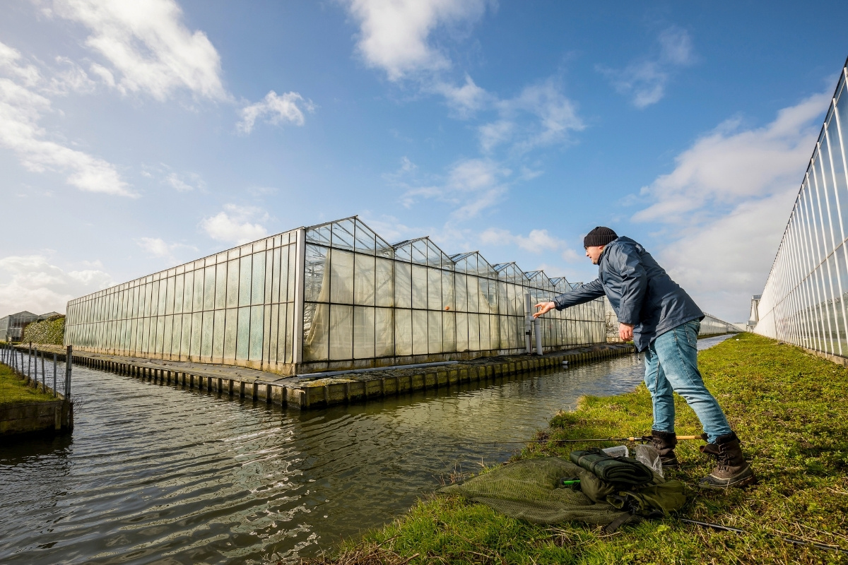 Angler füttert an einem Graben an