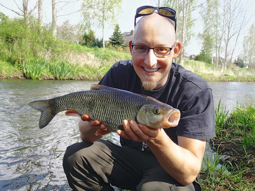Angler mit Döbel im Frühling