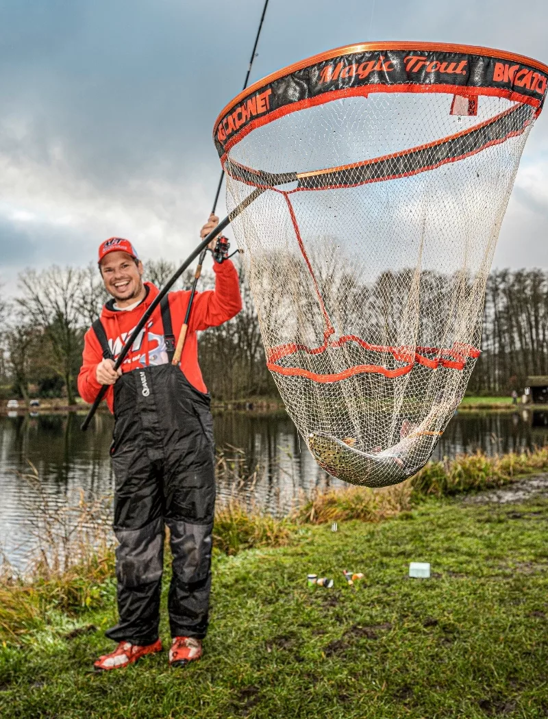 Angler mit Forelle im Kescher