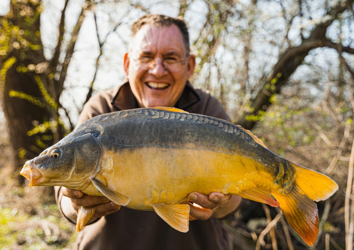Angler mit einem Spiegelkarpfen