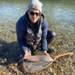 Fliegenfischer mit großer Äsche im Wasser
