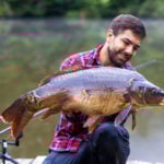 Angler mit Karpfen beim Karpfenangeln im Frankreichurlaub gefangen