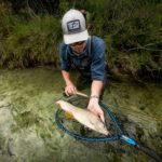 Angler mit Äsche im Fluss