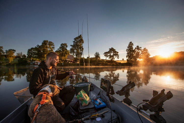 Bootsangler angeln Barsche in einem Waldsee