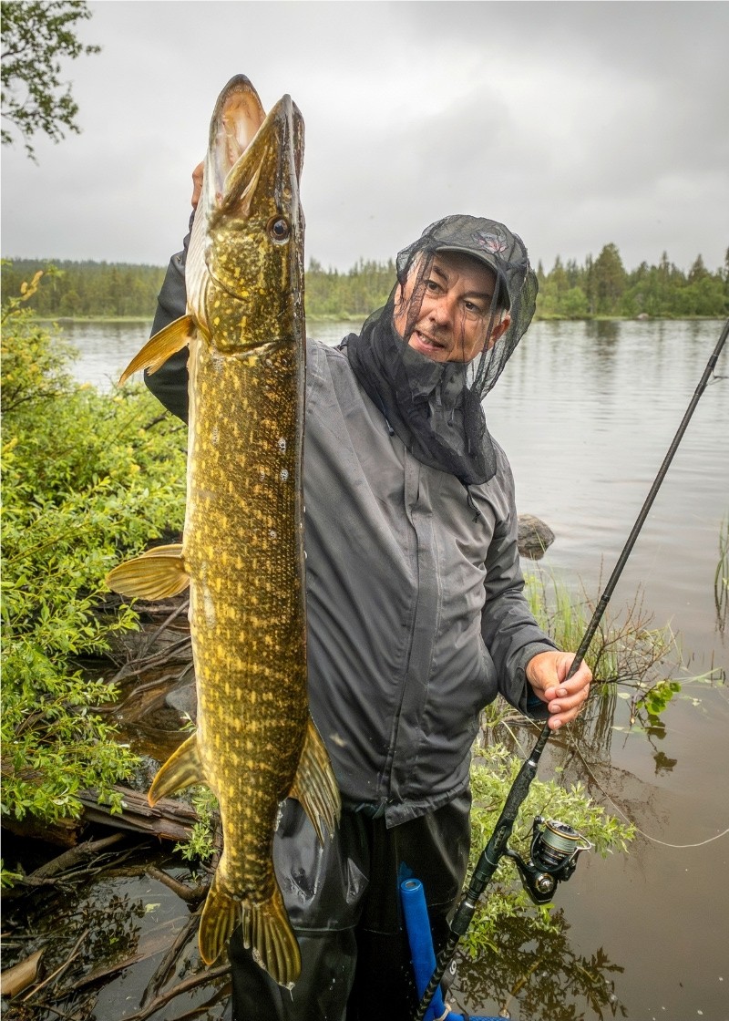 Angler mit Moskitonetz und Hecht