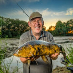 Angler mit Schleie auf einem Kraut-See