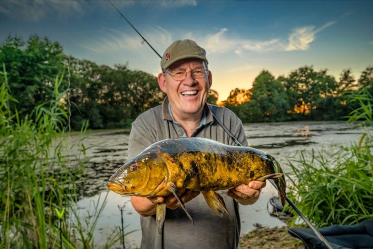Angler mit Schleie auf einem Kraut-See