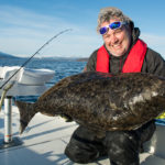 Angler mit Heilbutt, beim Slow Jigging in Norwegen gefangen