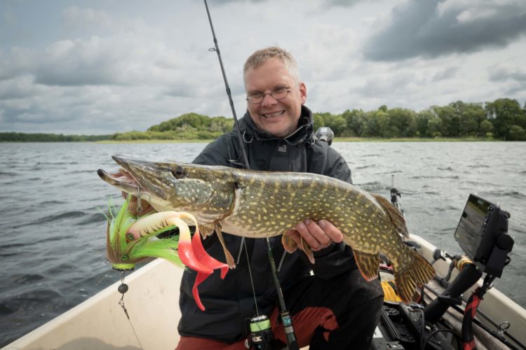 Angler mit Hecht auf Boot