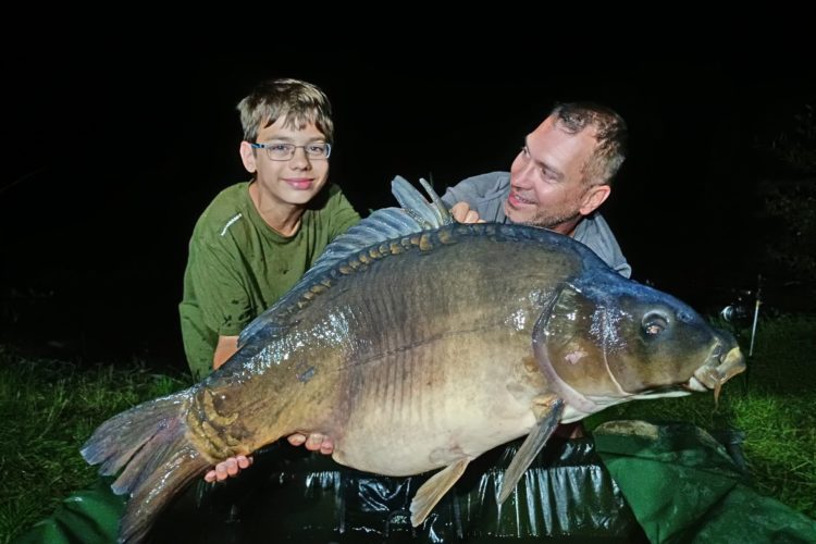 Vater und Sohn Wüst mit einem Karpfen