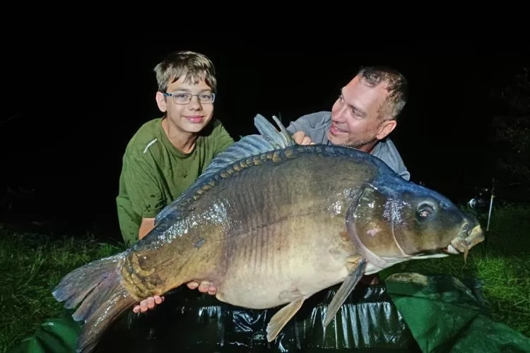 Vater und Sohn Wüst mit einem Karpfen