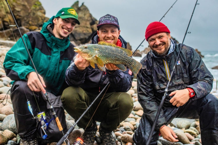 Drei Angler und ein Lippfisch an der Küste der Normandie