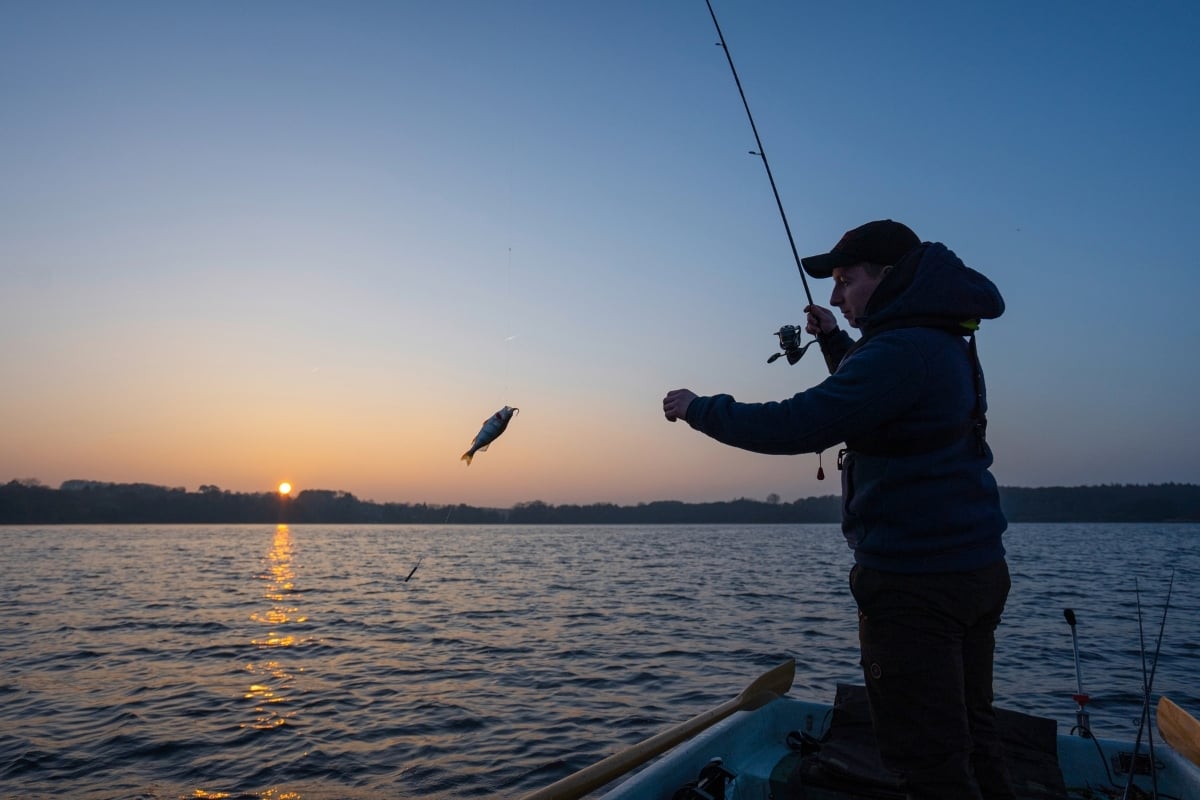 Angler beim Spinnfischen im Sonnenuntergang