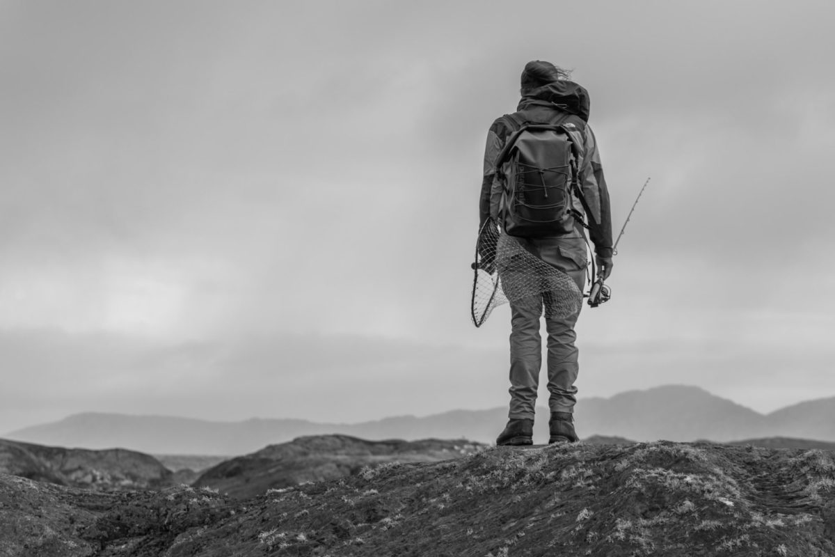 Angler mit Rucksack in den Bergen