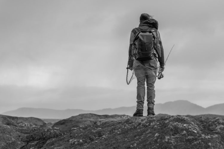 Angler mit Rucksack in den Bergen