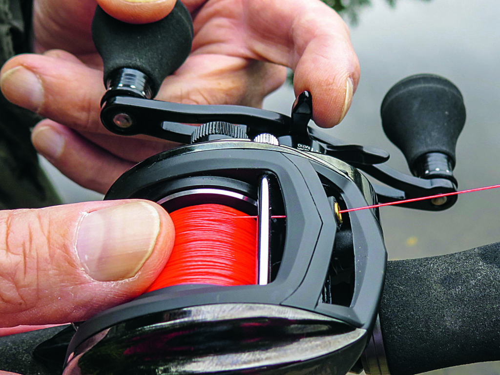 Baitcastrolle mit rotem Geflecht