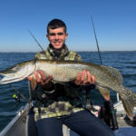 Angler mit Hecht auf Boot