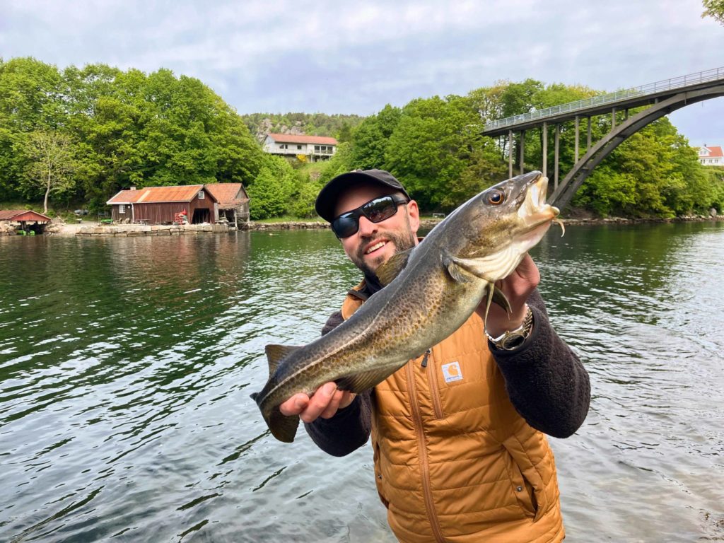 angler mit dorsch an einer brücke