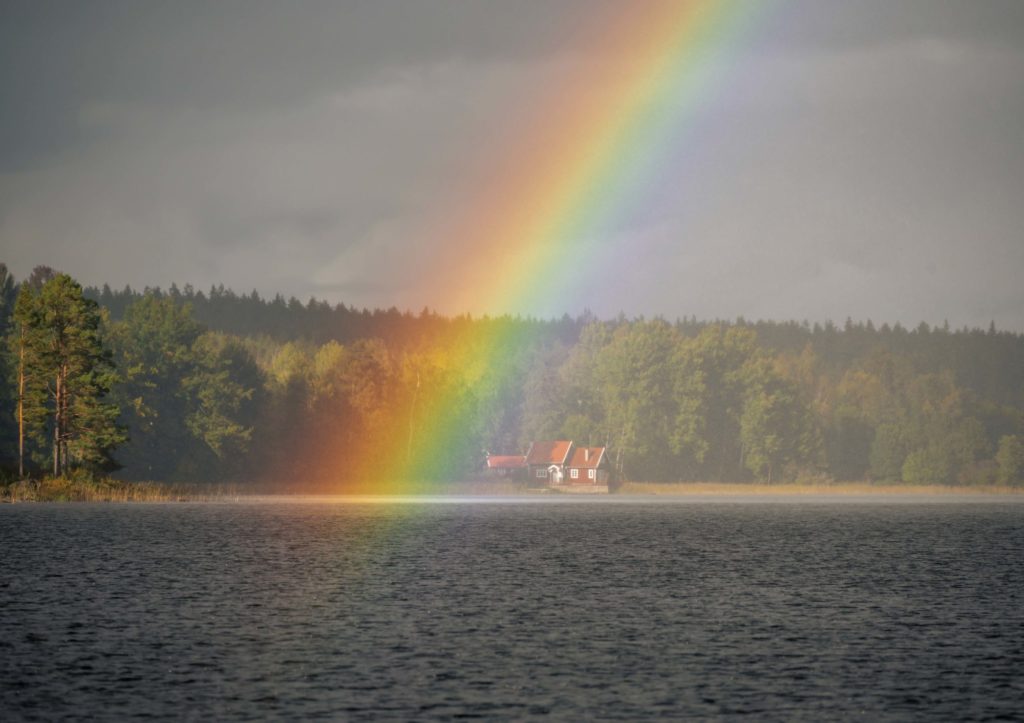 Ferienhaus am schwedischen See, Regenbogen über dem Wasser