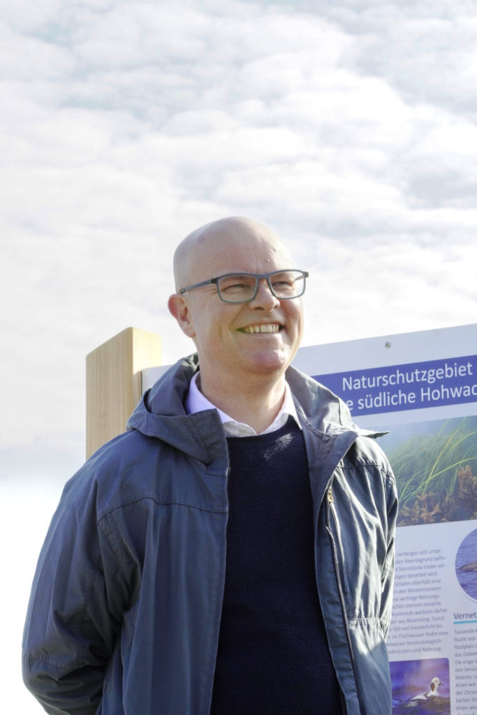 Minister Tobias Goldschmidt freut sich sichtlich bei der Einweihung der 1. Infotafel zu den neuen Schutzgebieten in Hohwacht am 23. März 2026.