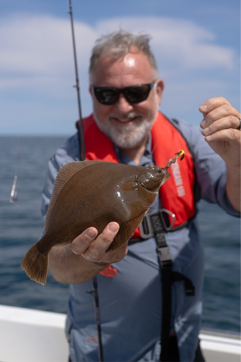 Angler mit Plattfisch auf einem Boot in der dänischen Ostsee