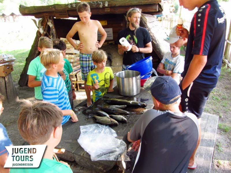 Mithilfe eines Betreuers wird der frisch gefangene Fisch von den Kinder für die Küche zubereitet. Foto: Jugendtours